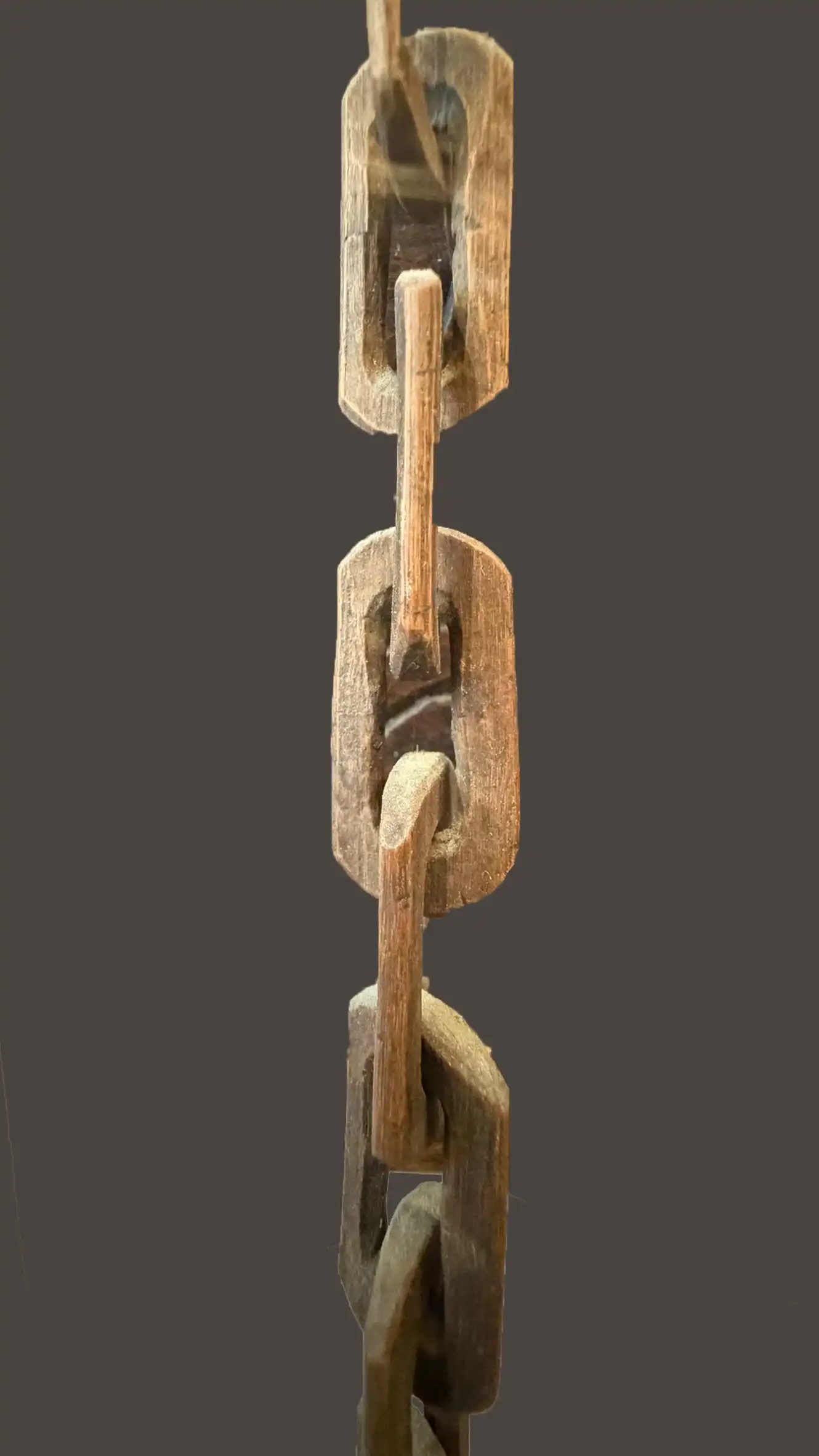 Hand-carved wooden chain with interlinked elements from a single piece
