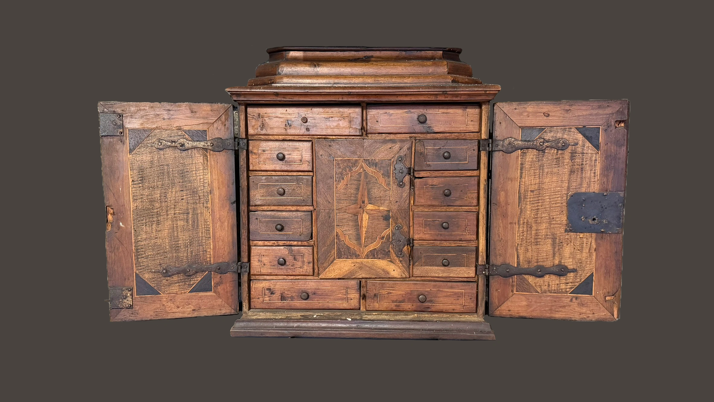 Kabinettschrank um 1750 mit gegliedertem Innenraum aus Schubladen und mittigem Kästchen, mit Marketerieeinlagen und Schmiedeeisenbeschlägen.