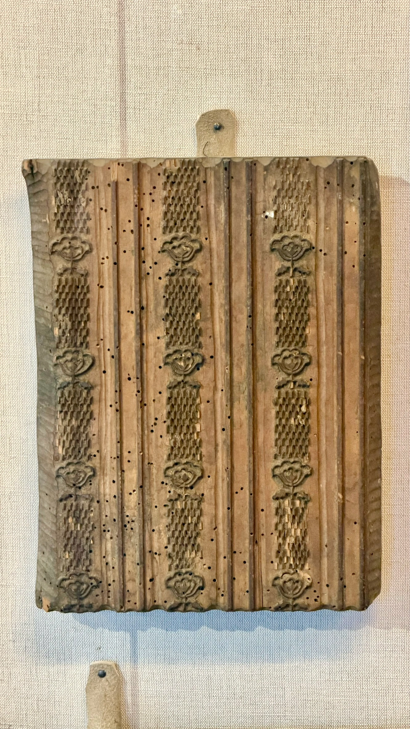 Wooden textile printing mould with vertical lines separating floral motifs