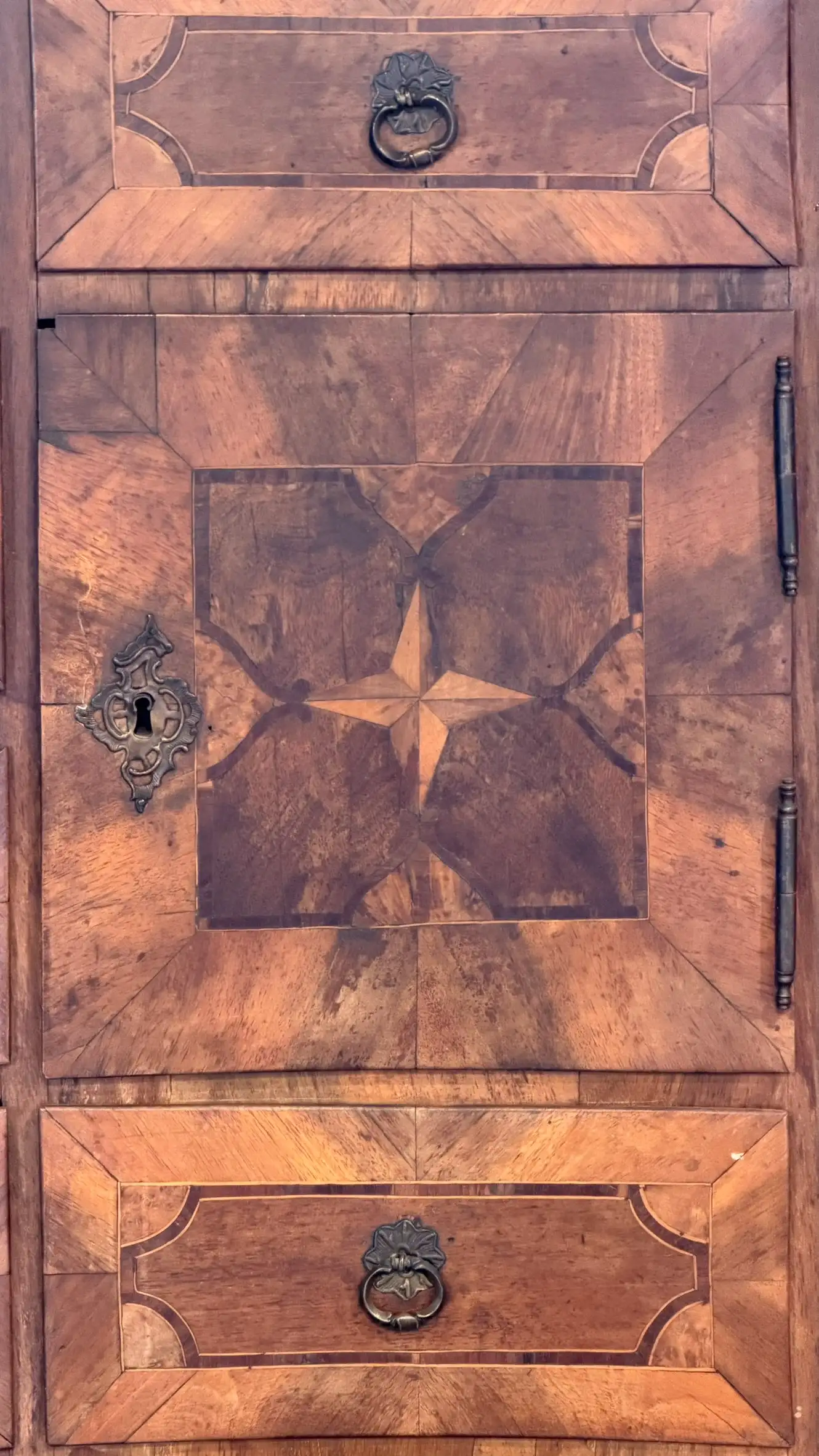 Detail der Marketerietürfüllung mit zentralem Sternmotiv und ornamentalem Schlüsselschild.